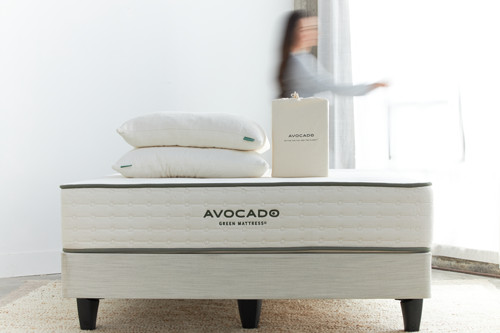 Avocado mattress with pillows and packaging on display.