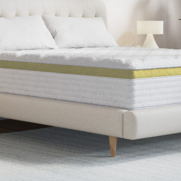 Comfortable bed with white linens and lamp.