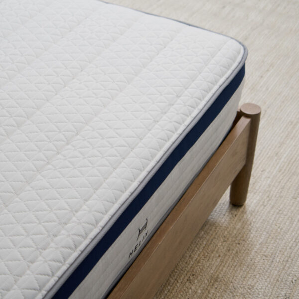 Comfortable mattress on wooden bed frame