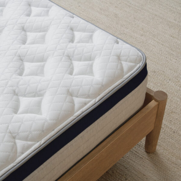 Quilted mattress on wooden bed frame