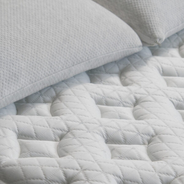 White quilted mattress and pillows close-up view.
