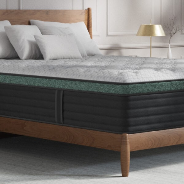 Comfortable mattress on wooden bed with pillows.