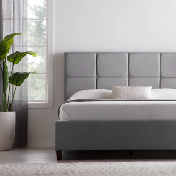 Modern gray bed with potted plant and window view.