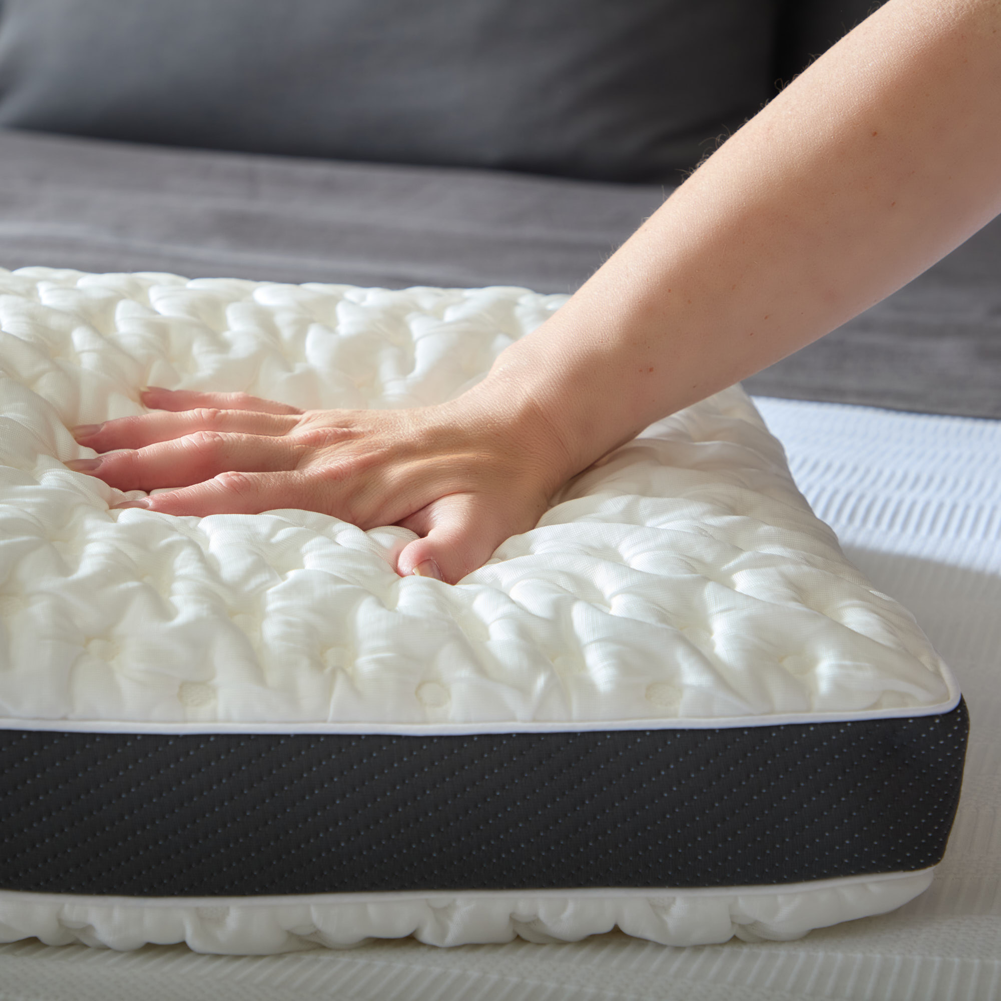 Hand pressing memory foam mattress for softness test.