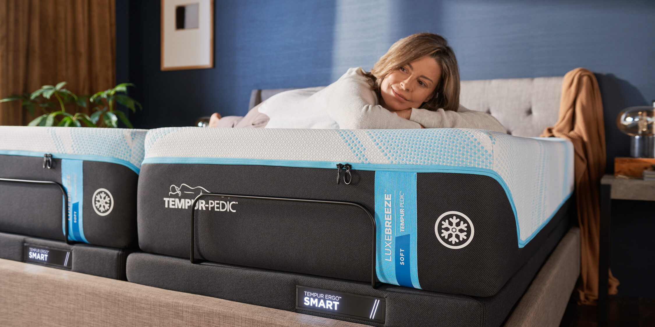 Woman relaxing on Tempur-Pedic LuxeBreeze mattress.