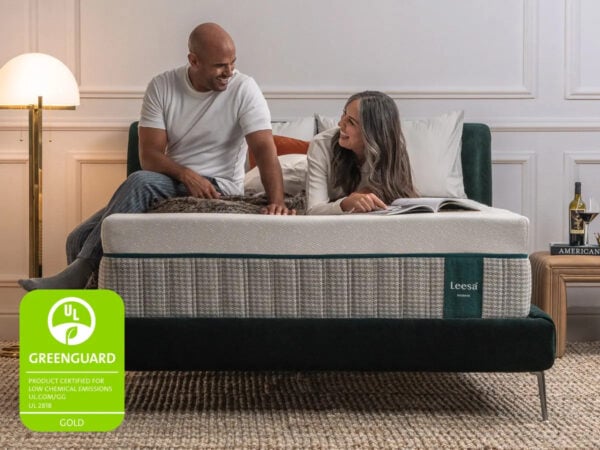 Couple relaxing on a Leesa mattress with Greenguard certification.