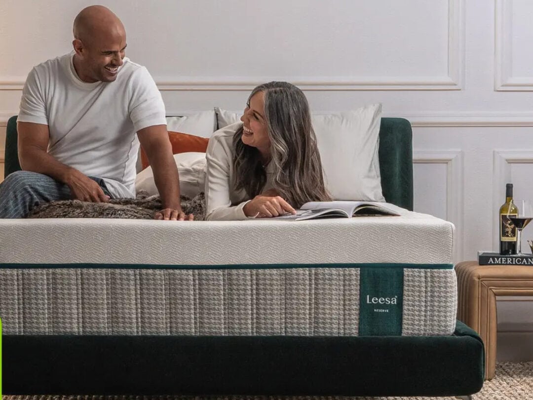 Couple smiling on Leesa mattress in bedroom